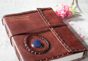 Leather and stone are a magic combination, made durable by nature and authentic by our design. Our Ra collection of leather journals features a stone motif to create an energetic and visible impact. The Lapis Lazuli is the eye of inner power and represents wisdom and enlightenment of the mind. This carefully selected, midnight blue semi-precious stone is aesthetically embedded in rugged, yet soft and supple buffalo hide. Beautifully contoured with hand stitched leather cord around the stone and journal to create a dimensional frame and intrepid feel. The exposed spine binding is pure leather cord which has been hand sewn to hold the pages in place and will certainly stand the test of the time.